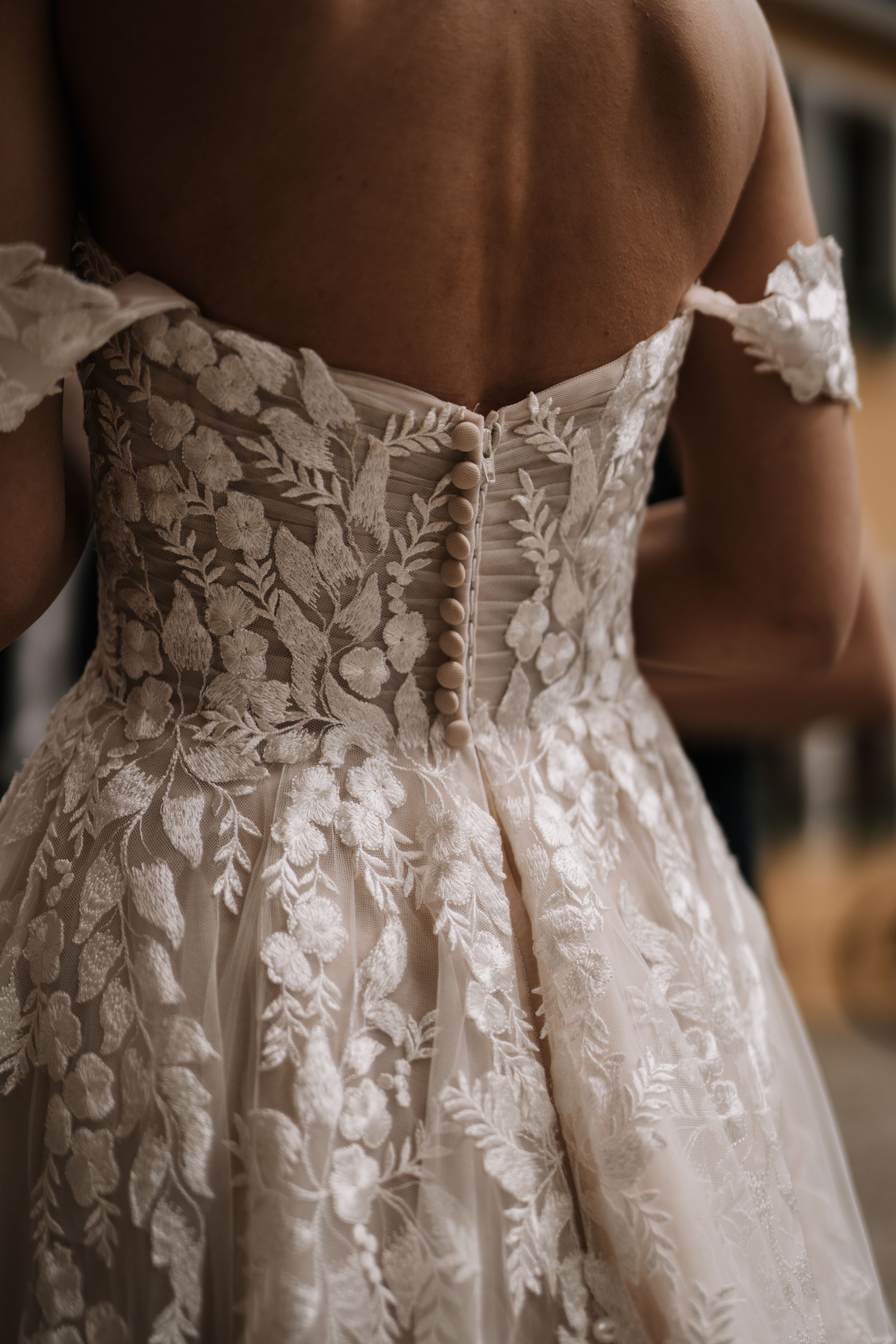 Intricate white floral lace detail on the back of a wedding gown.