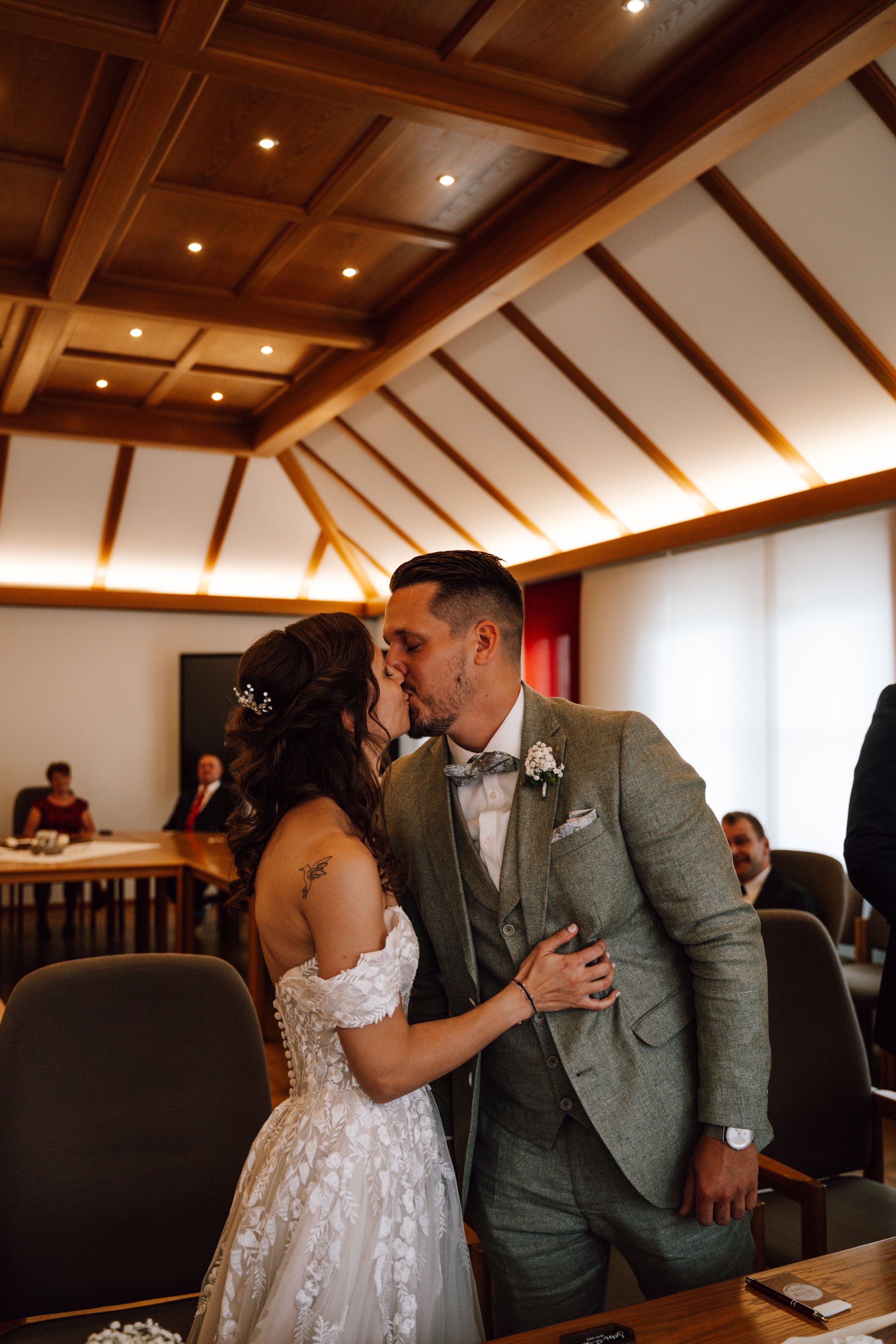 Wedding ceremony in a room with wooden coffered ceiling and warm lighting.