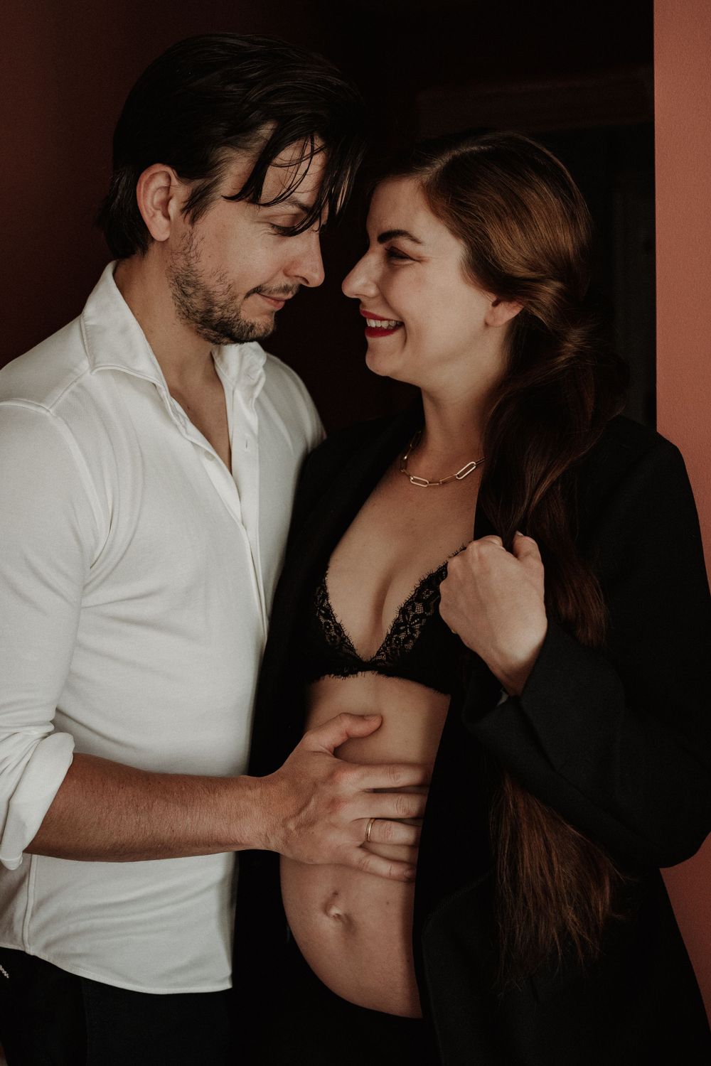 A romantic couple sharing an intimate moment in contrasting white and black outfits.