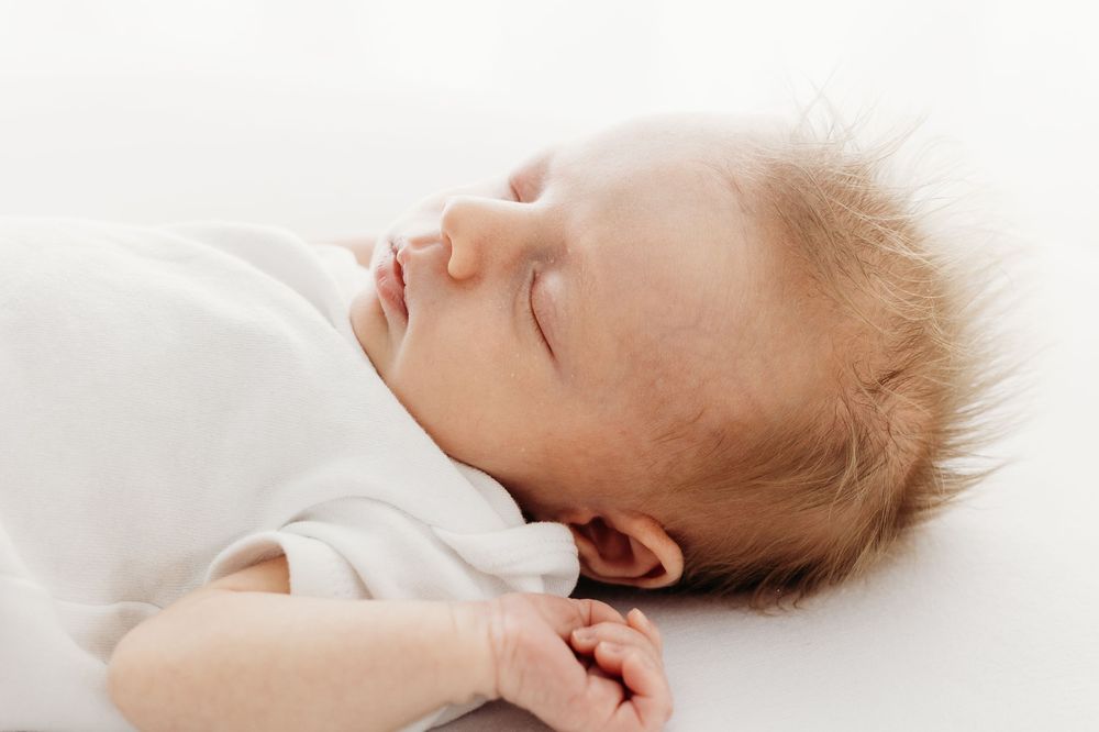 Newborn asleep on textured blanket in Mapperley studio, Nottingham photographer creating calm, minimal portraits.