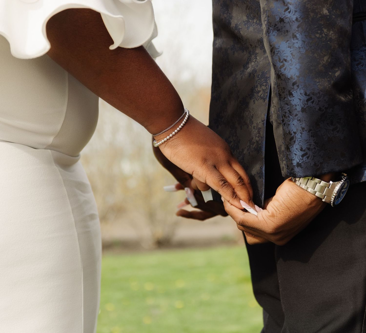 Close-up of hands during wedding ring exchange ceremony.