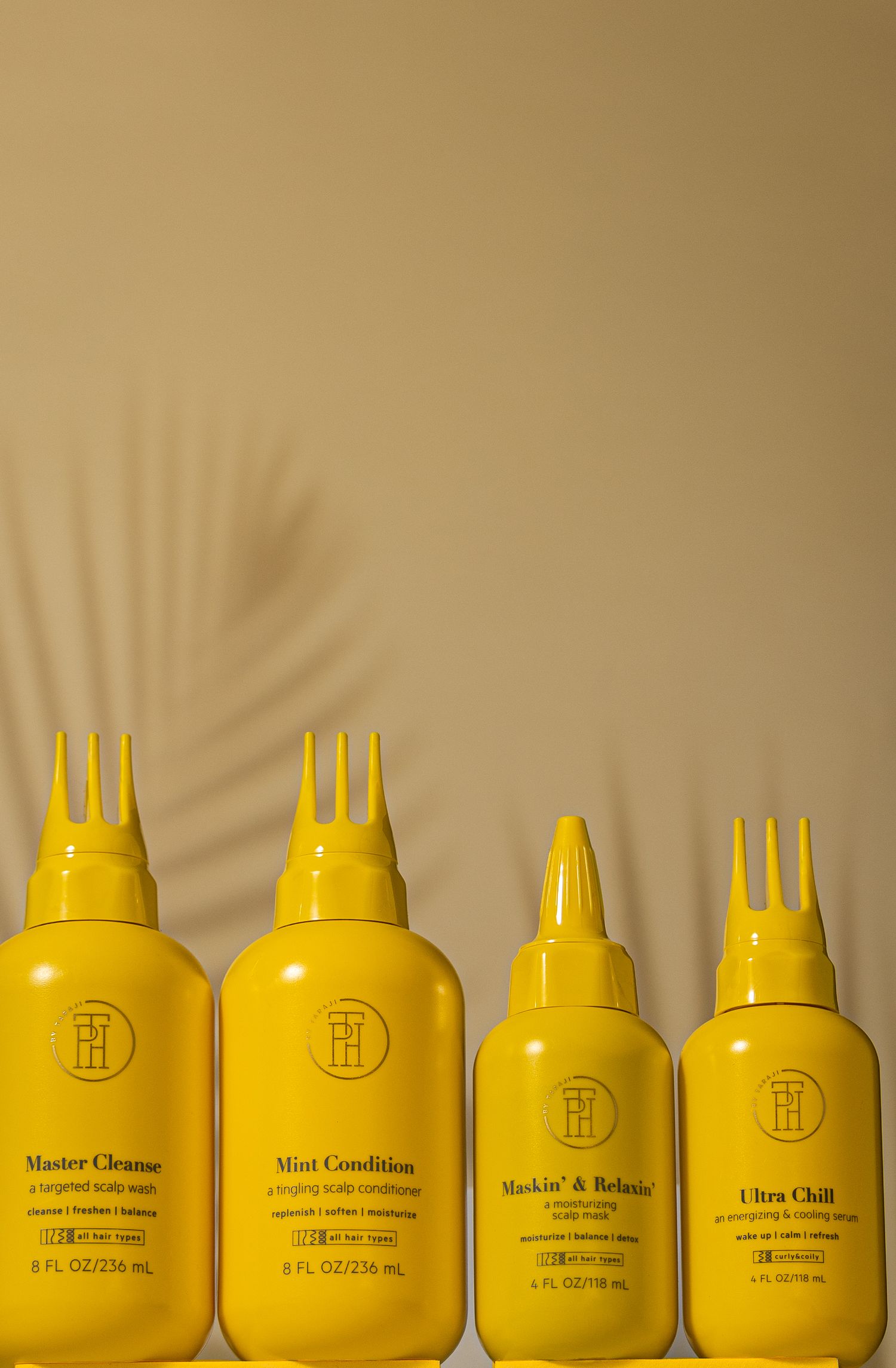 Four yellow hair product bottles arranged in descending height order against tan background with palm shadow.