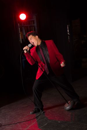 High school boy singing onstage in theater