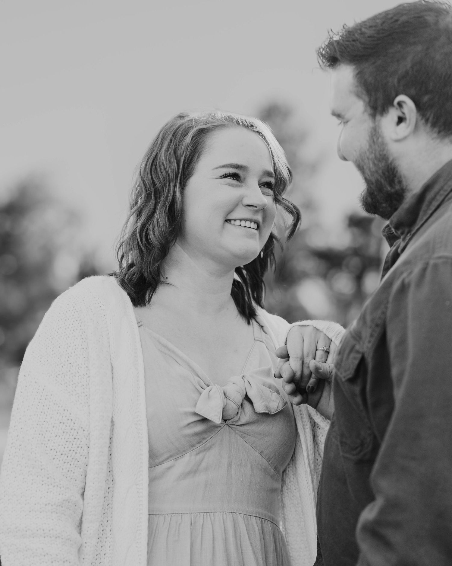 A romantic black and white photo of a couple sharing a joyful moment together outdoors.