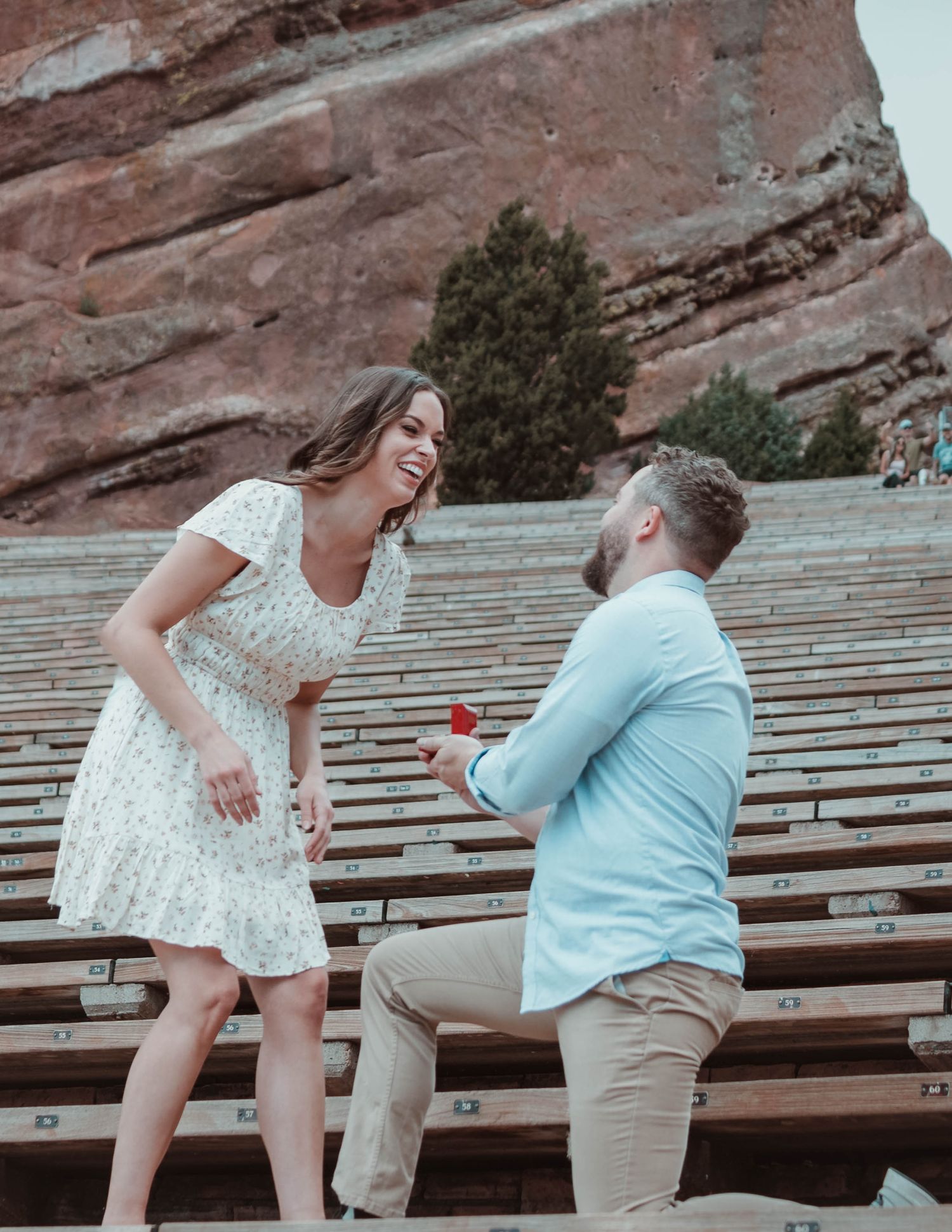 A proposal moment captured at Red Rocks Amphitheatre with dramatic rock formations in the background.