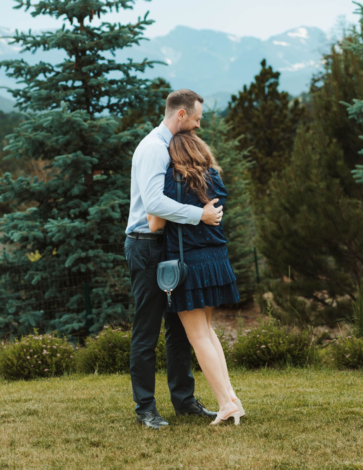 A couple sharing an intimate moment in front of a stunning mountain landscape.