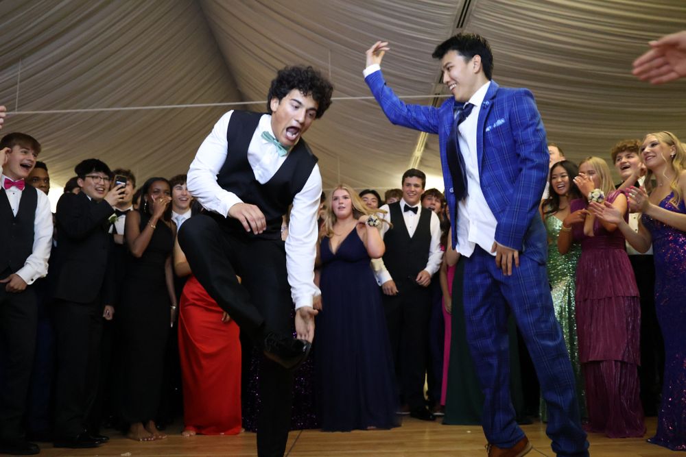 Two performers dancing and entertaining crowd in formal attire at special event.