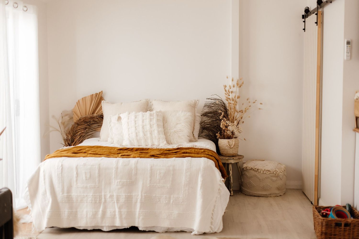 Minimalist white bedroom interior with soft natural lighting.