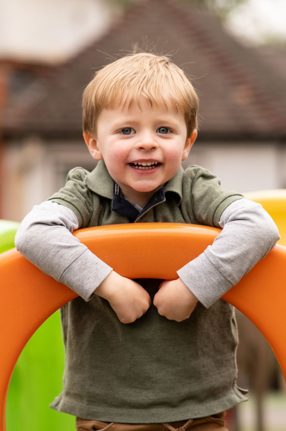 Young boy in the playground during a nursery photoshoot, in Ashtead, Surrey