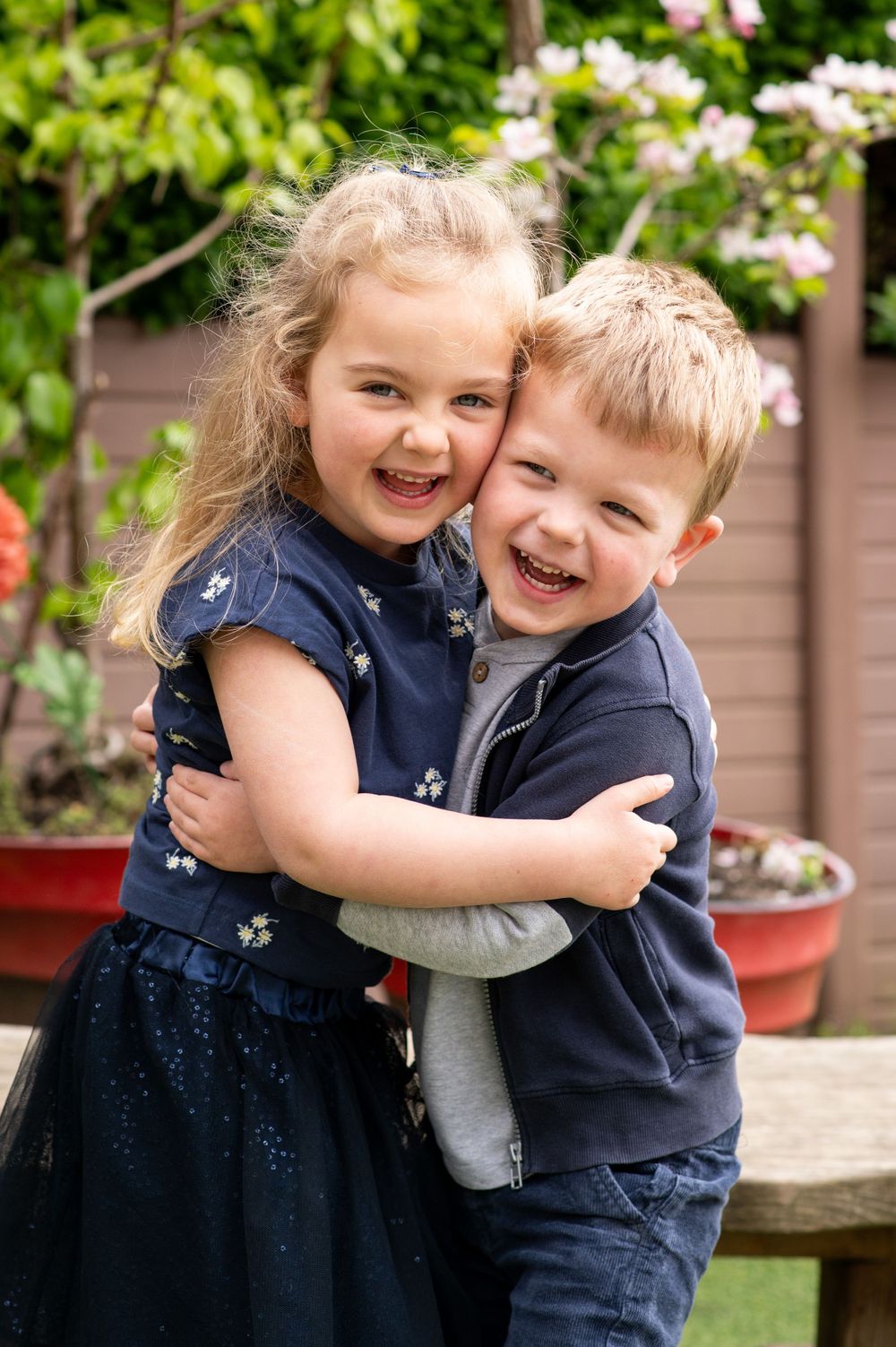 Brother and sister cuddling during a nursery photoshoot, in Ashtead, Surrey