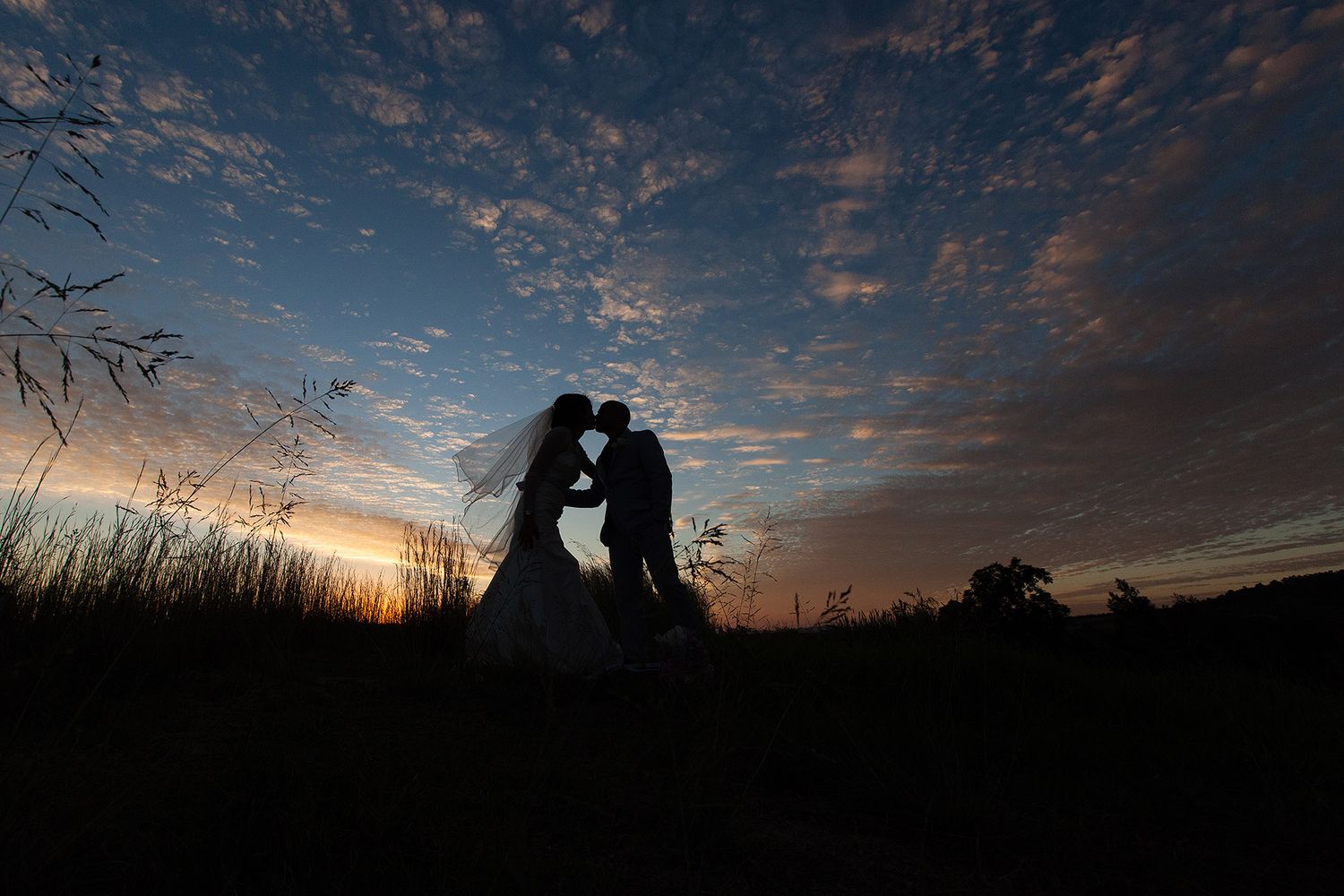 Elopement couple enjoying the stunning sunset with a kiss (Romantic Elopement Photoshoot by Lesley Marks)