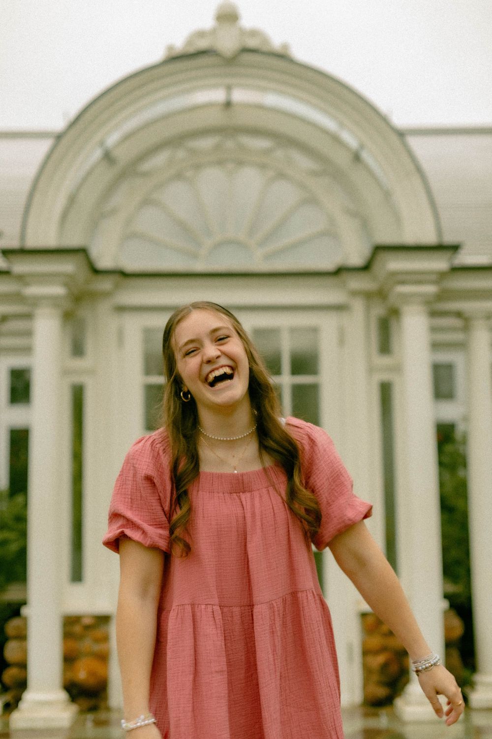 A joyful moment captured in front of a white classical building with an ornate arched entrance.