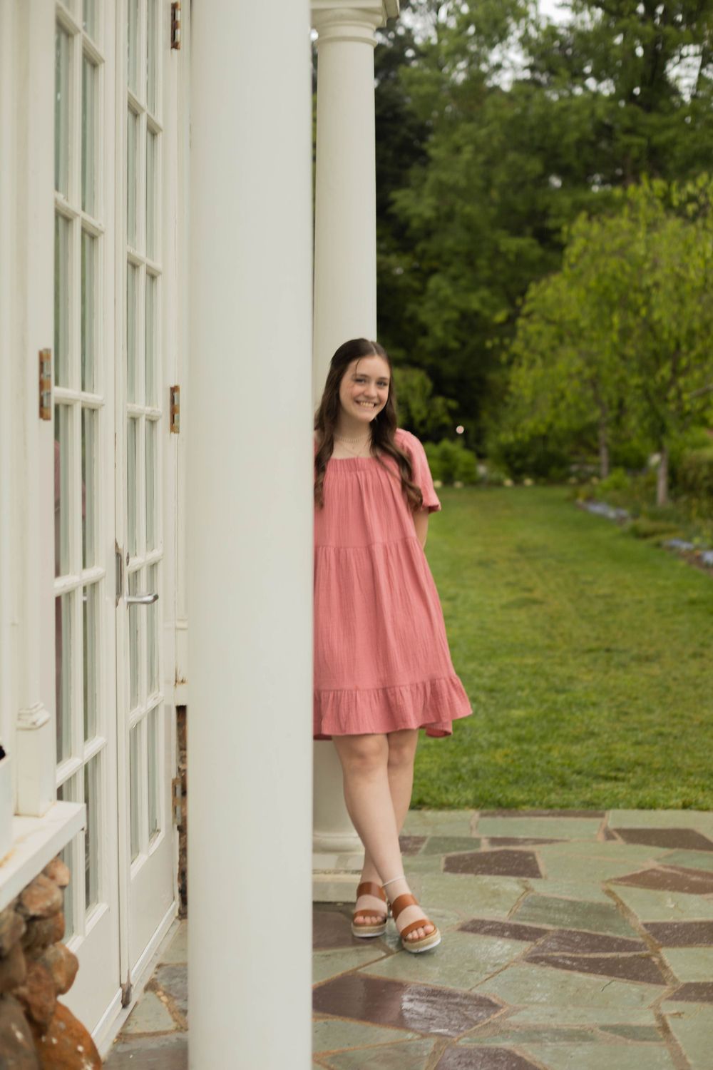 Casual summer portrait against white colonial architecture and manicured garden grounds.