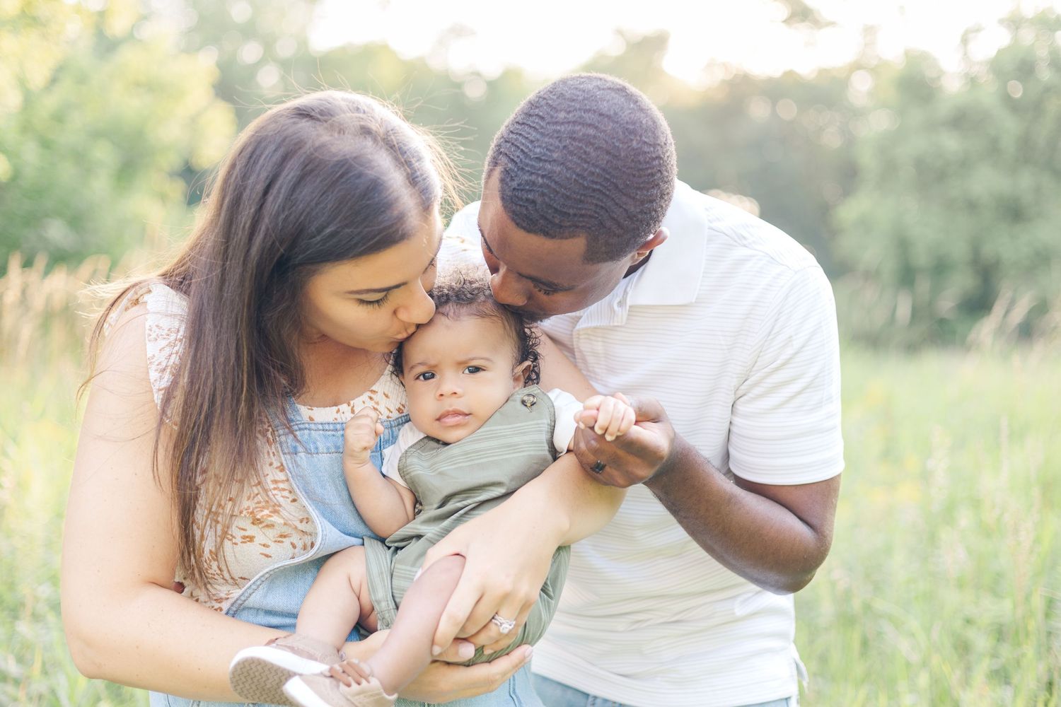 Tender family moments captured in outdoor field during sunset photography session.