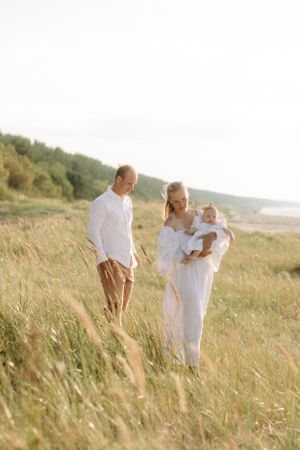 Family portrait in golden sunlit field at sunset.
