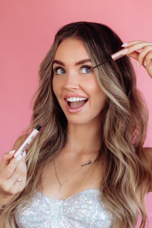Beauty portrait series with sparkly makeup and joyful expressions against pink background.