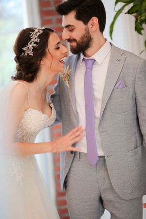 An intimate wedding portrait showing a tender moment between newlyweds in formal attire.