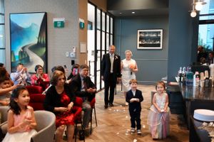 Children and guests gather in a modern venue space with blue walls and landscape artwork.