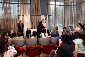 Event attendees seated in rows of chairs watching a presentation in an elegant venue.