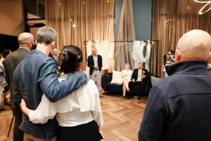 Intimate gathering in an event space with draped fabric and decorative elements.