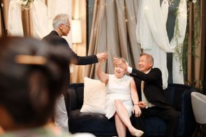 Candid moment during an event with guests seated on a blue sofa.