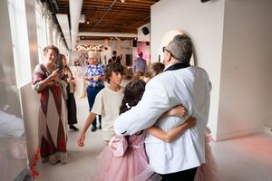 Couples dancing together in a bright studio space with white pillars and exposed wooden beams.