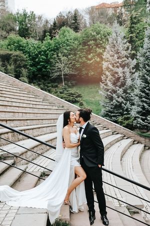 A romantic moment on stone amphitheater steps surrounded by lush greenery.