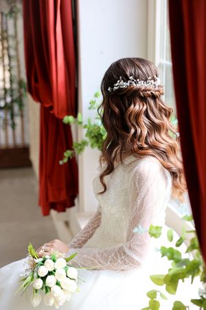 An elegant bridal hairstyle with wavy curls and delicate hair accessories.