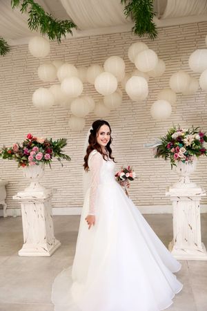 An elegant wedding reception setup with white lanterns and floral arrangements.