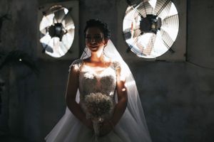 Dramatic bridal portrait with industrial fans creating unique lighting effects.