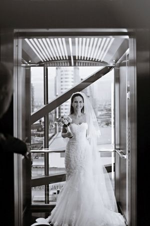 A classic bridal portrait in an elevator with dramatic lighting and cityscape view.