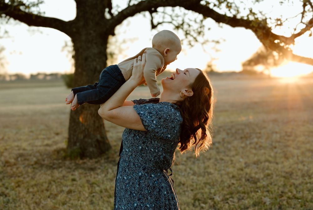 Mom lifting baby up and smiling