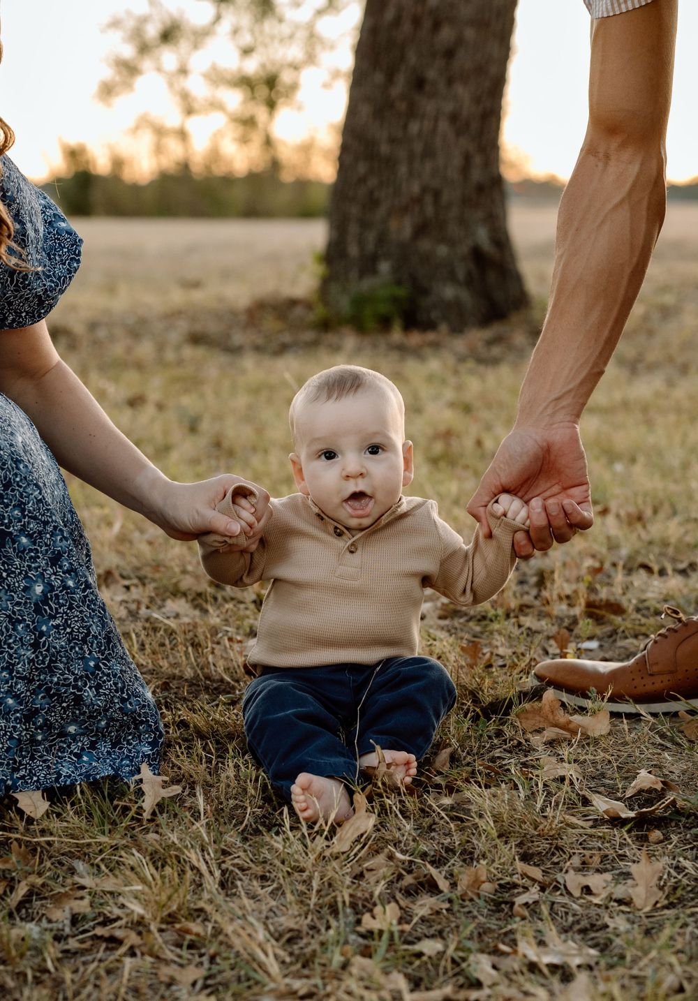 baby holding parents hands