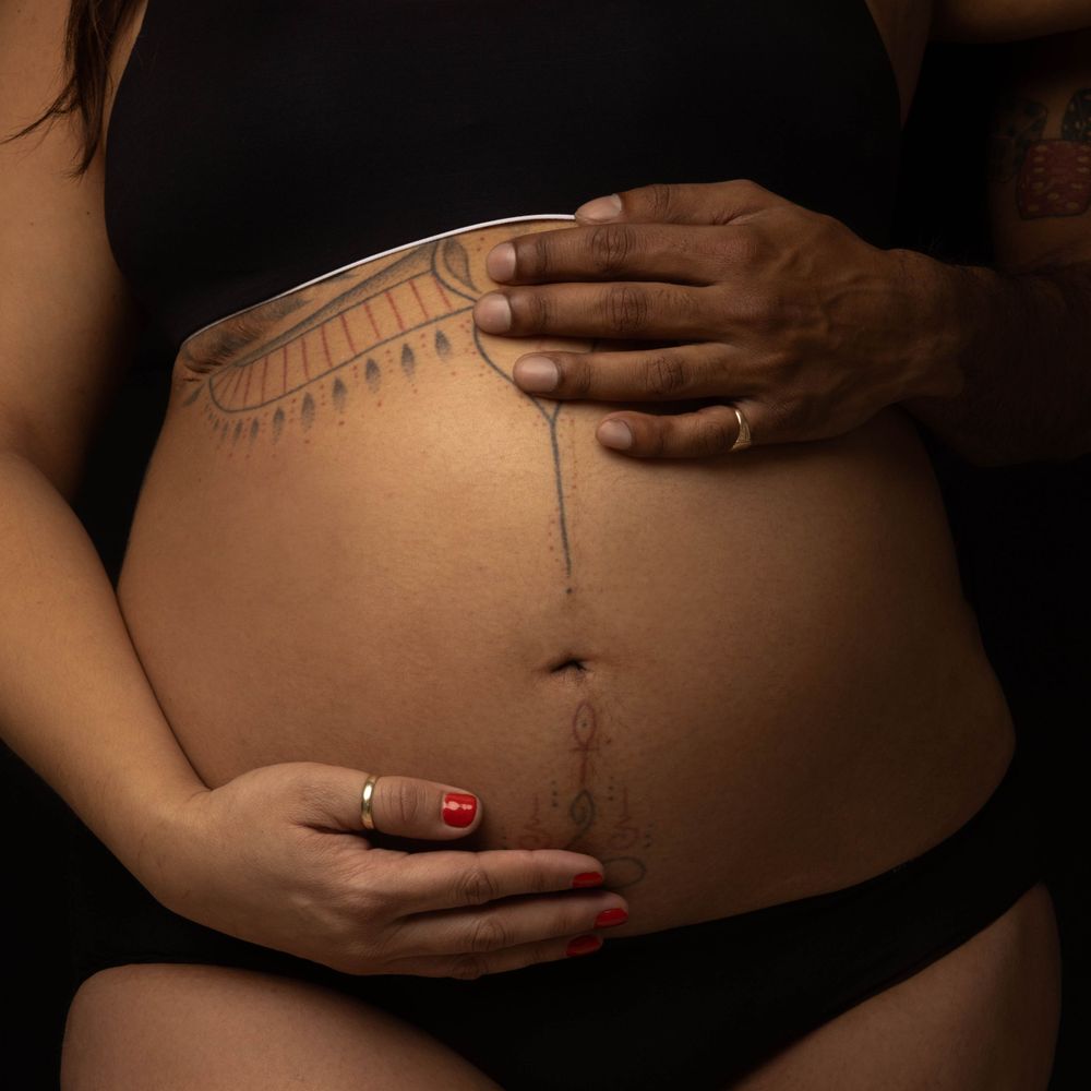 Lovely photo of a pregnant womans belly.  Belly is seen with beauitul tattoo.  This image was shot in a photo studio in Long Island.