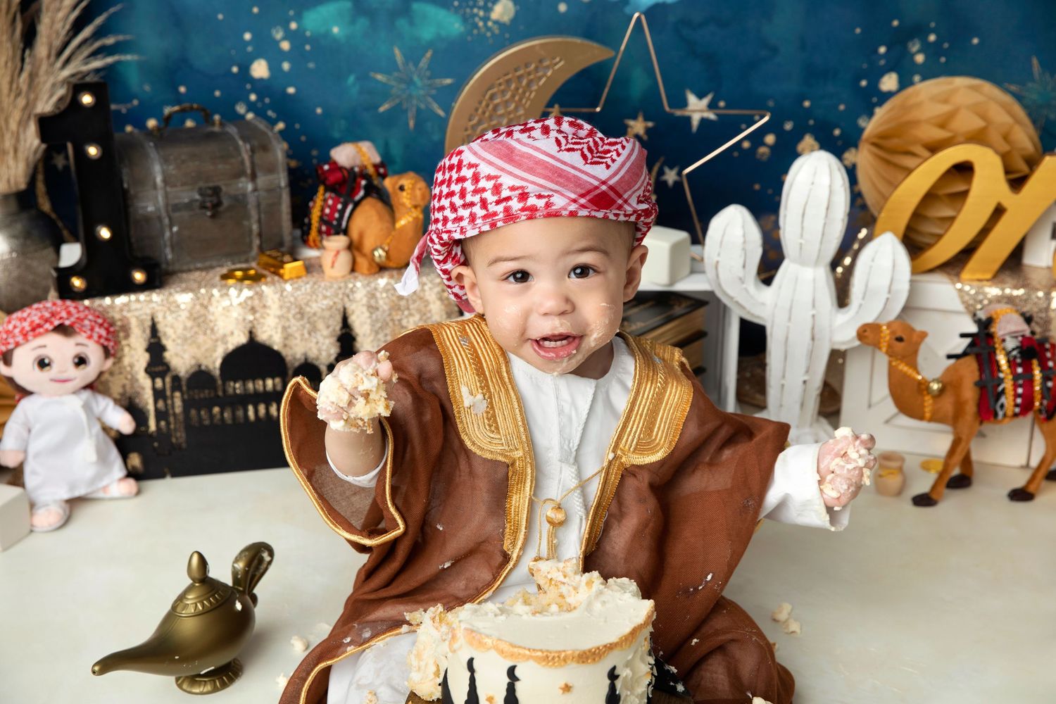 Magical nighttime themed photo setup with gold accents and white picket fence decorations.