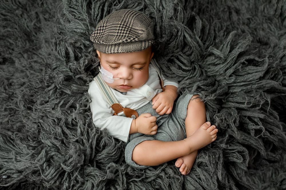 Affordable newborn photographer Ipswich Hospital and Mater Mothers Brisbane – baby boy in newsboy cap sleeping on soft grey fur, Springfield