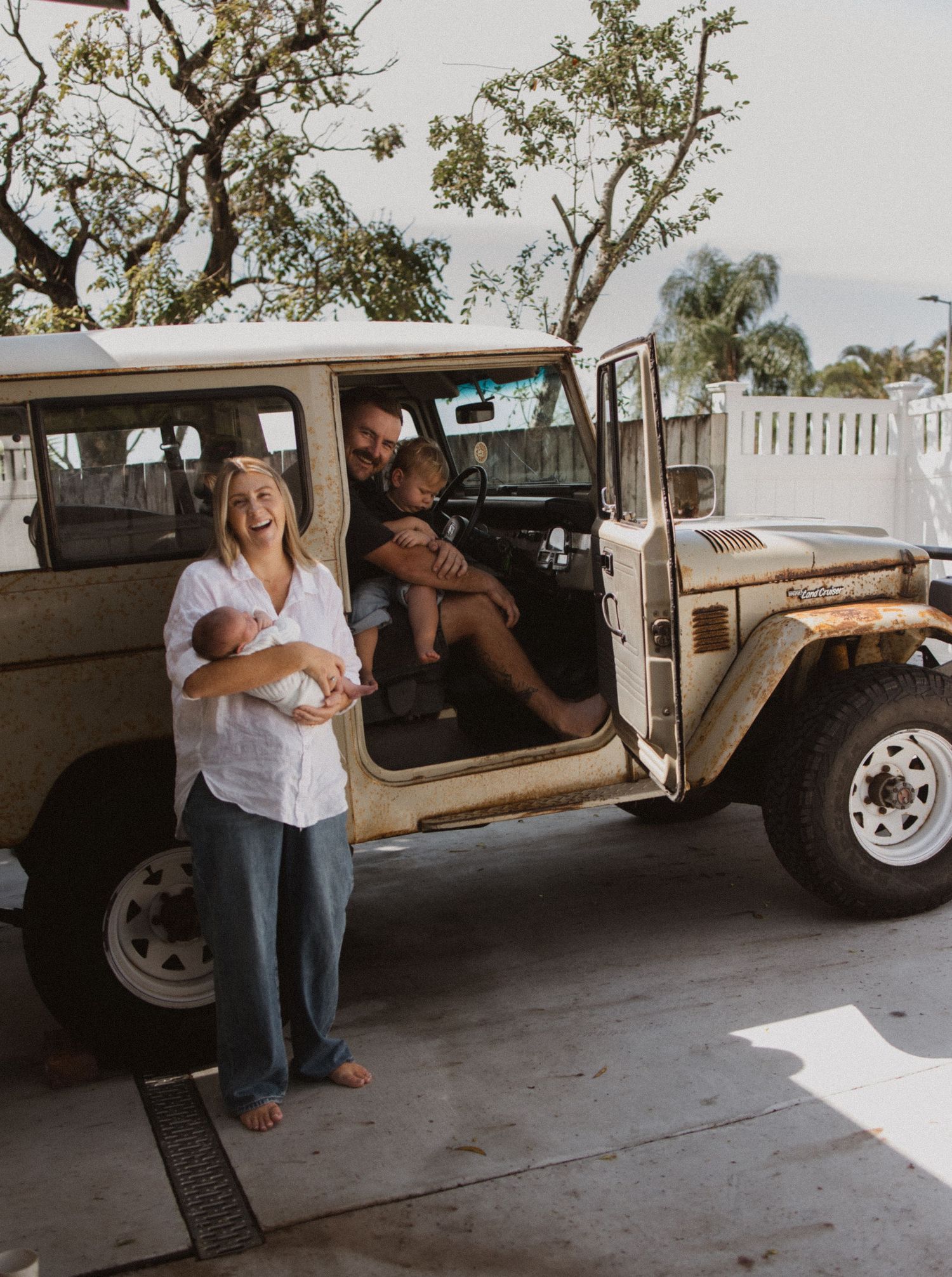 A couple embraces next to a vintage pickup truck in a romantic engagement photo session.