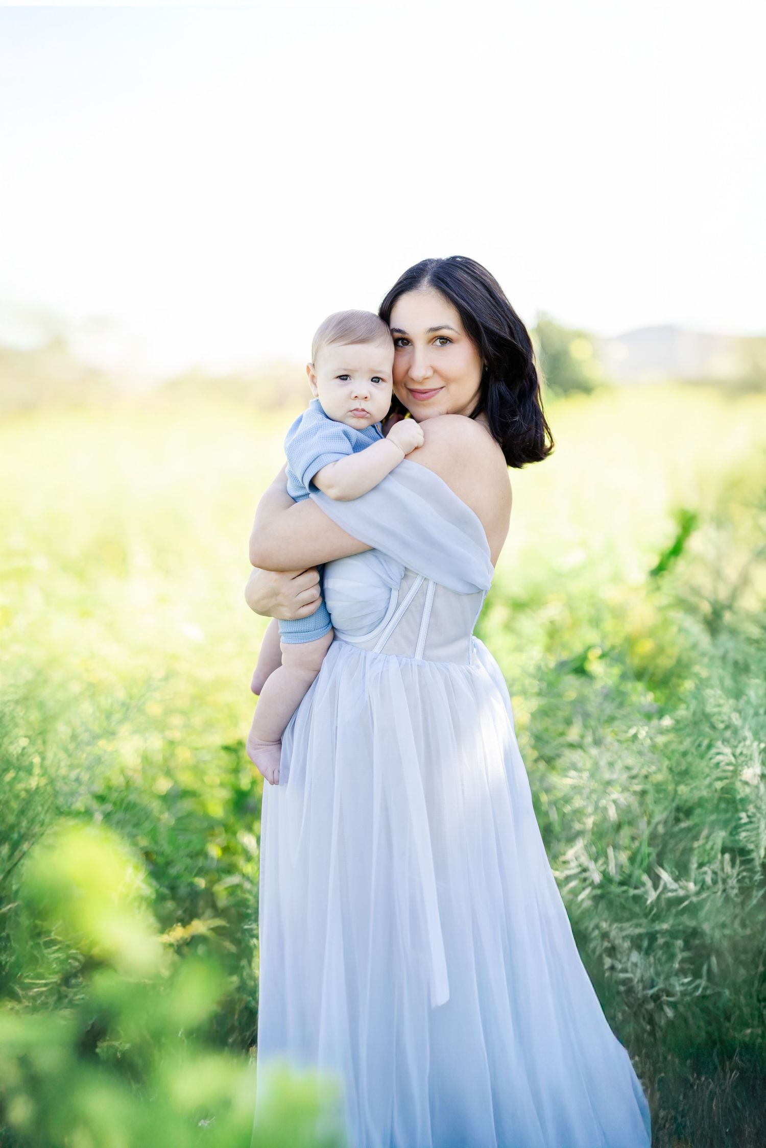 Family shares tender moments together outdoors during a maternity photo session.