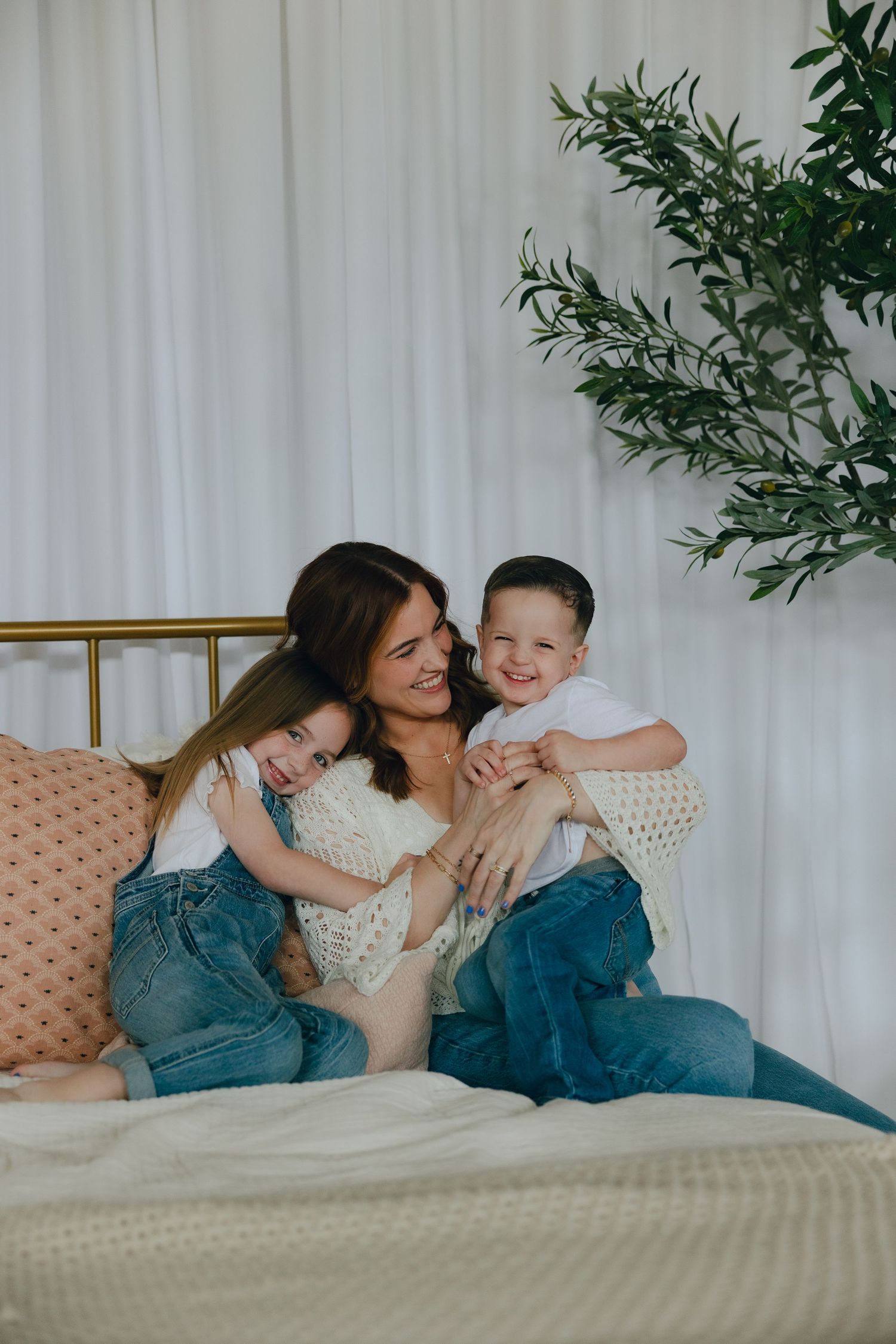 A joyful family moment captured on a blanket in a grassy field during golden hour.