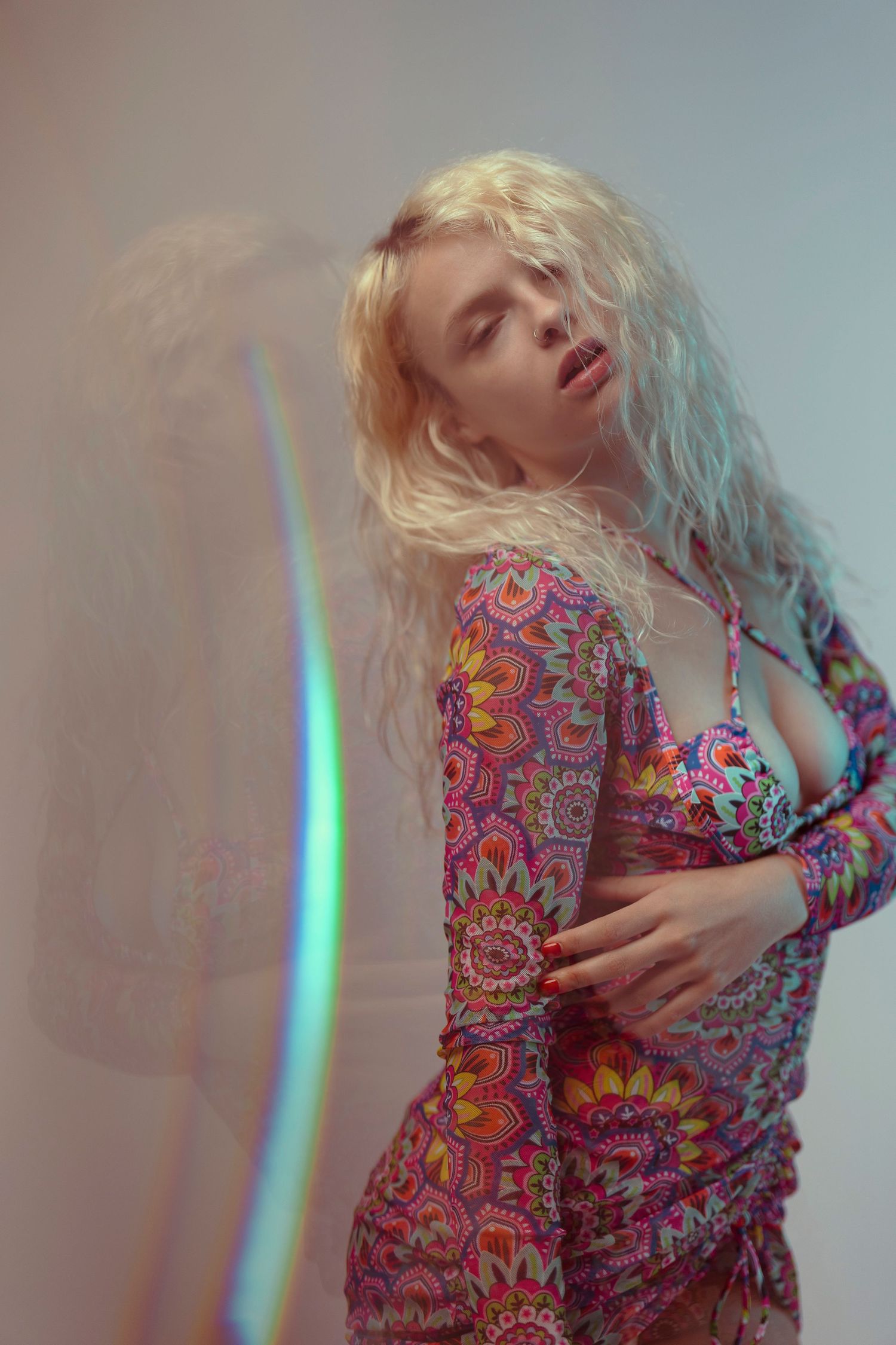 Fashion portrait featuring colorful psychedelic print dress with dreamy lighting effects.