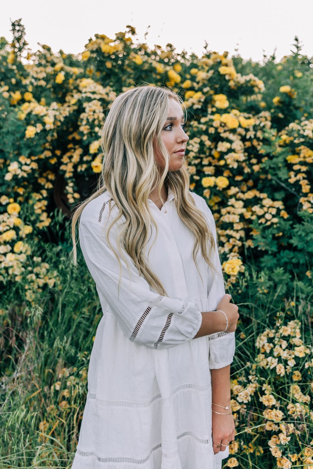 Girl in White In Front of Yellow Flowers