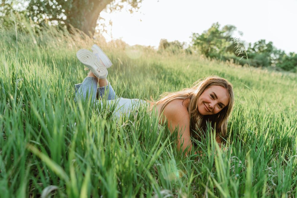 Girl Laying in Tall Grass Near Tree