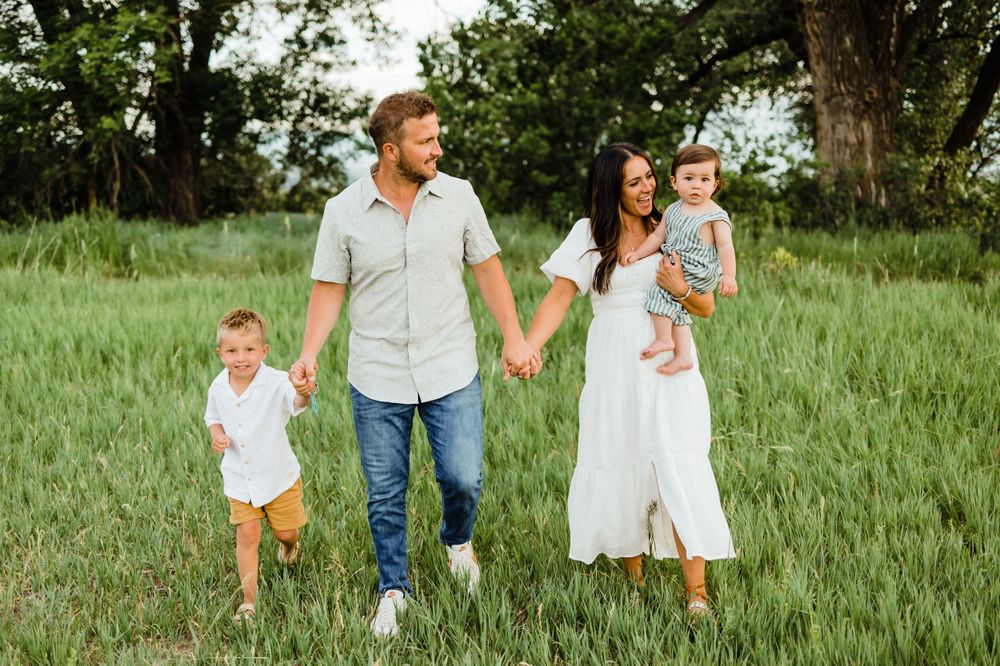 Beautiful Family of Four in Field Wearing Neutral Colors