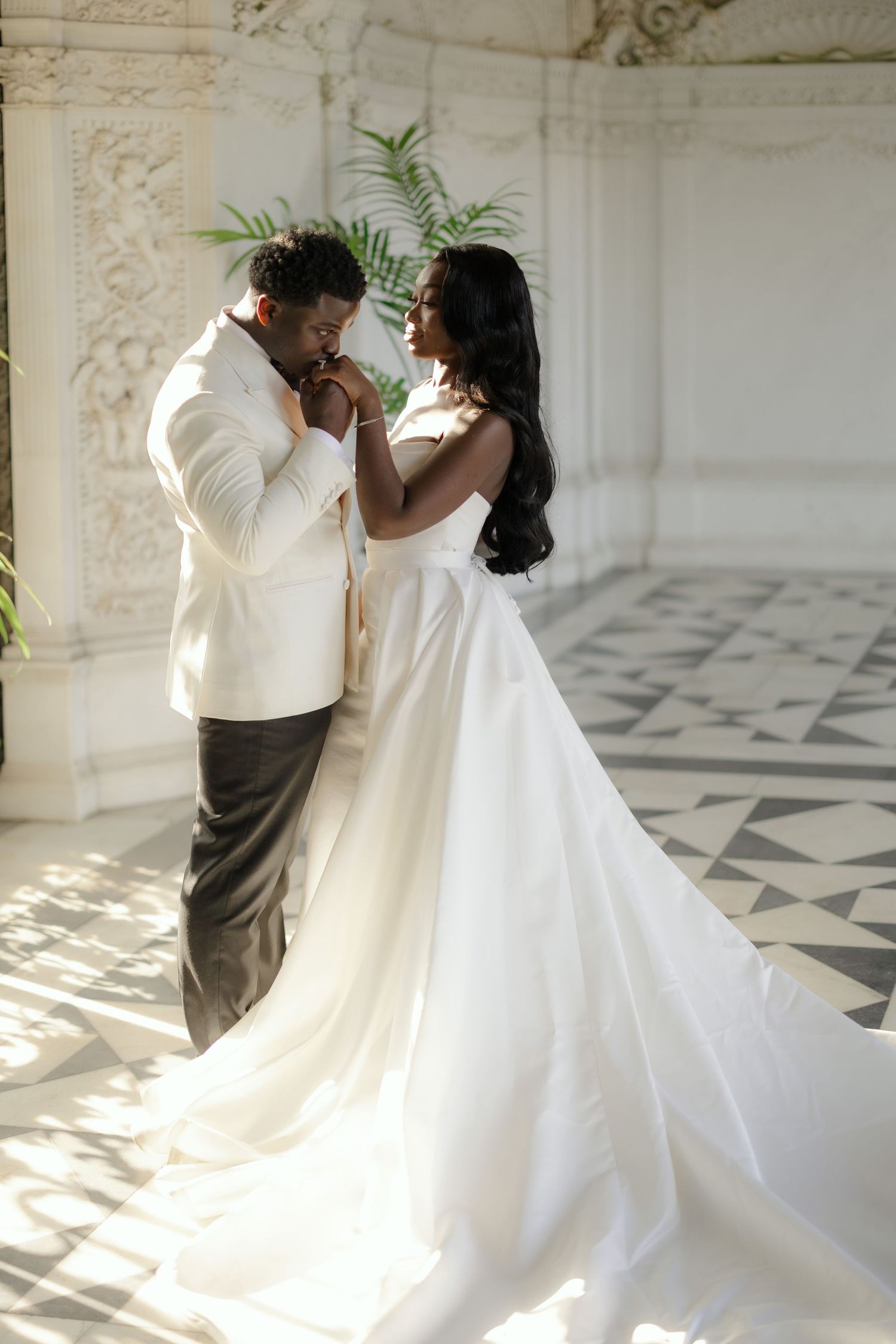 Romantic wedding moment captured between couple in white formal attire sharing an intimate moment.