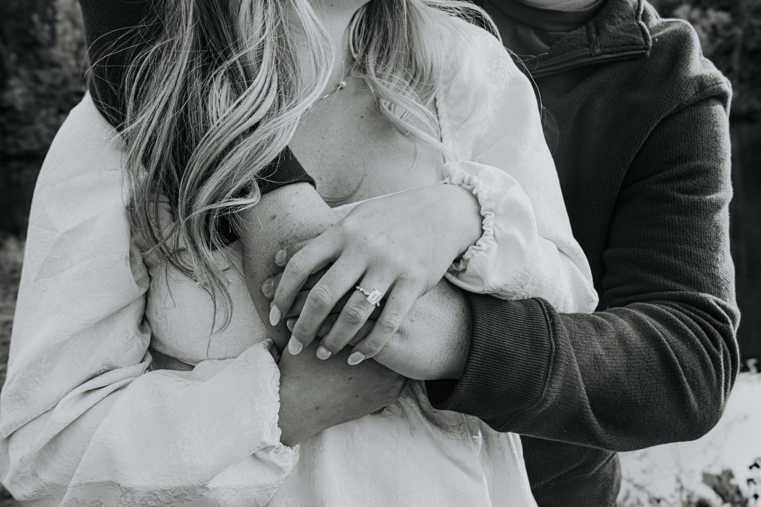 Close up of engaged couple's hands holding an ultrasound photo showing their future baby.