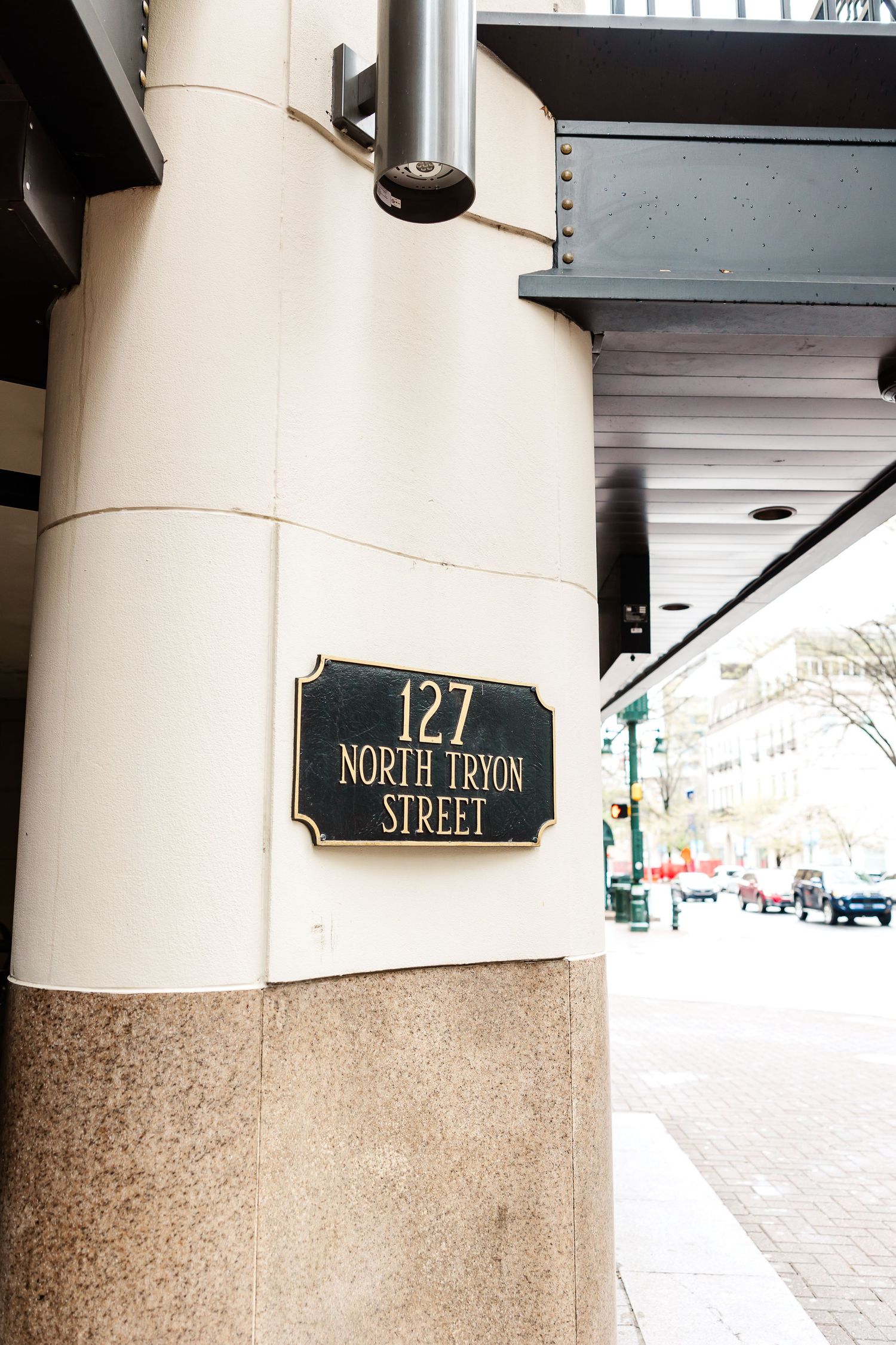 Close-up view of a building address number 127 and North Pryor Street sign mounted on a stone and white column.