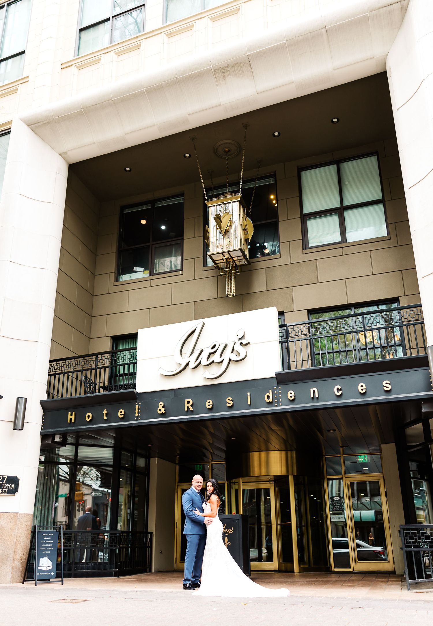Hotel and residences entrance with modern glass doors and signage on a beige building facade.