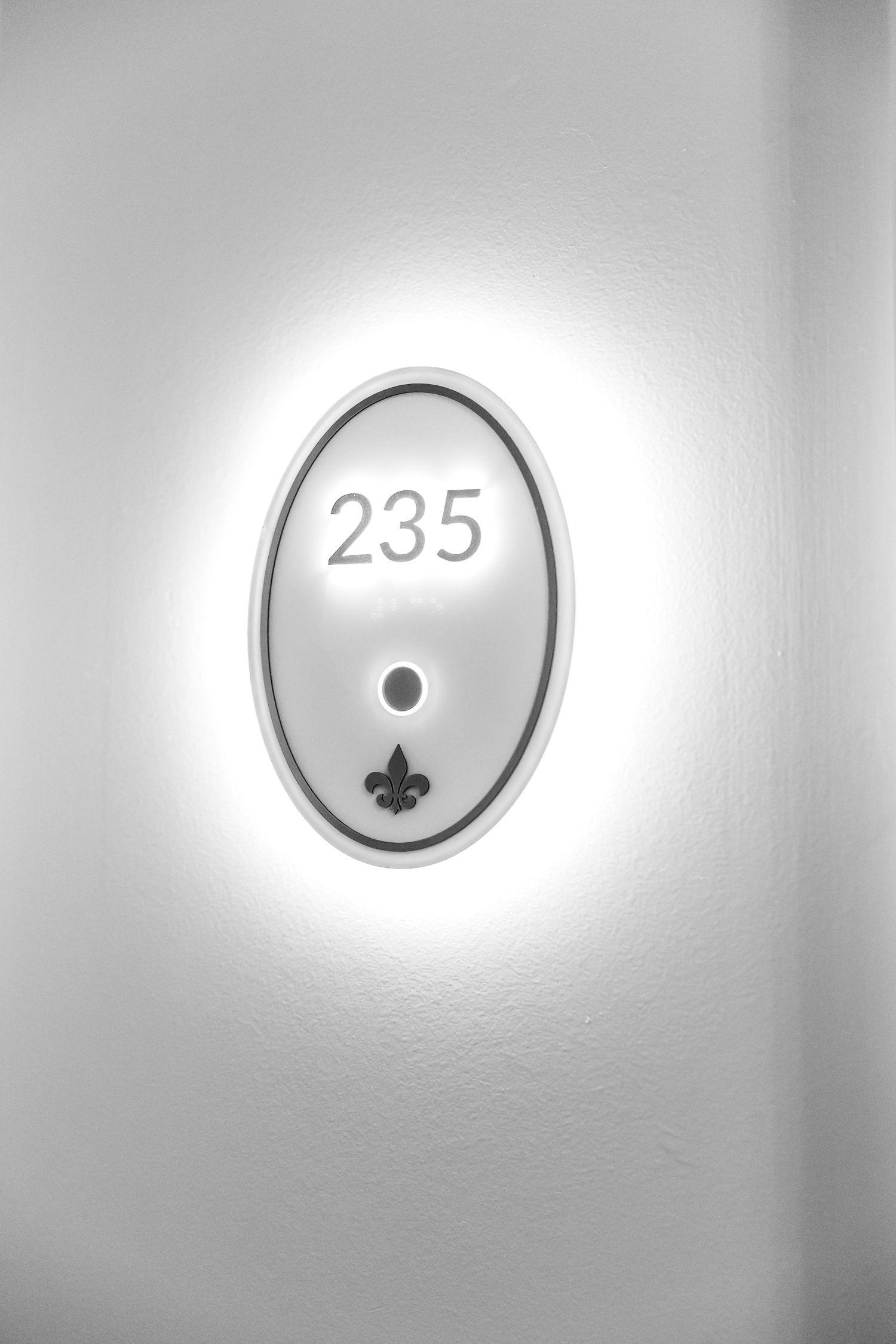 A series of illuminated circular light fixtures mounted on a gray wall showing different numerical displays and symbols.