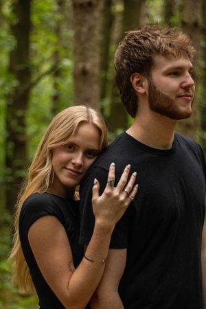 A couple shares a tender moment together in a wooded outdoor setting during a couples photoshoot.