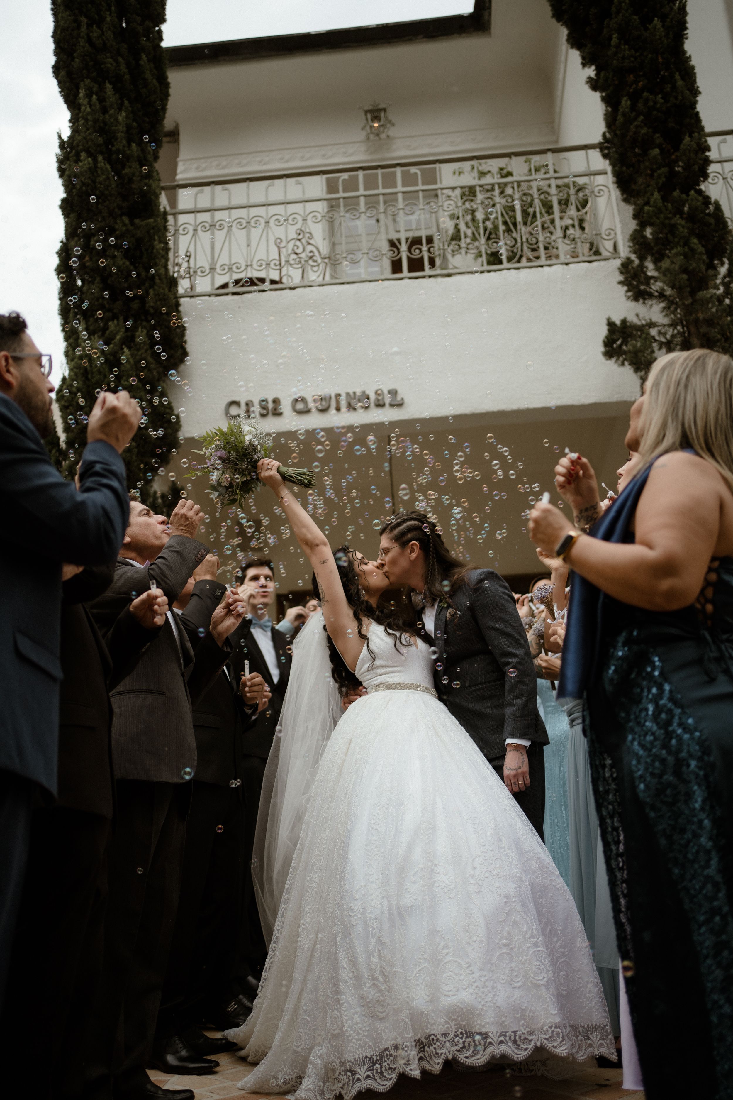 Wedding celebration with guests blowing bubbles outside Casa Quinio venue.